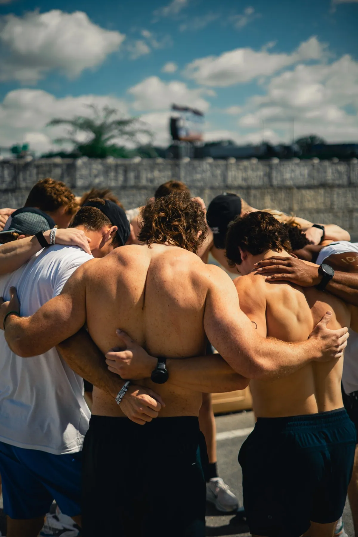 The Vessel Training community arm in arm in a prayer huddle
